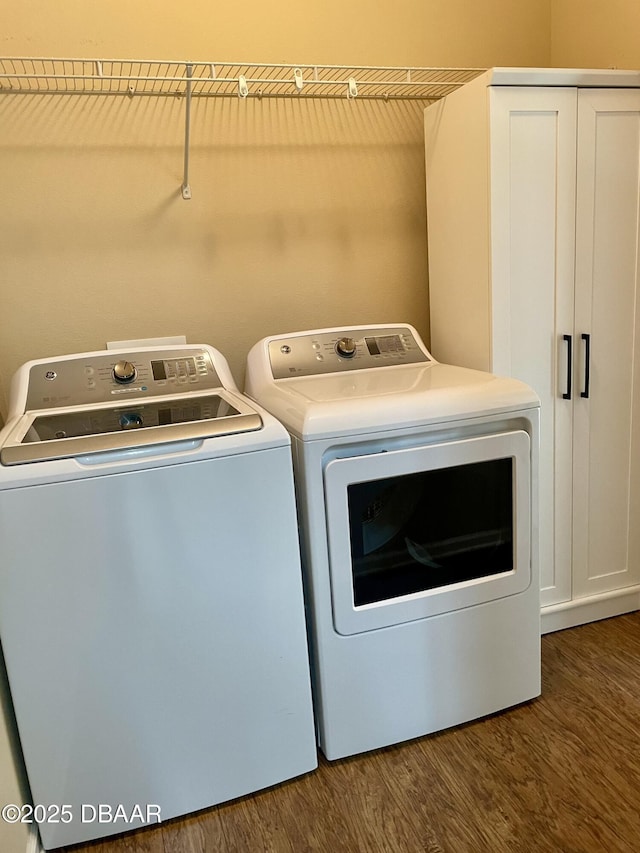 laundry area with washing machine and dryer and dark wood-type flooring