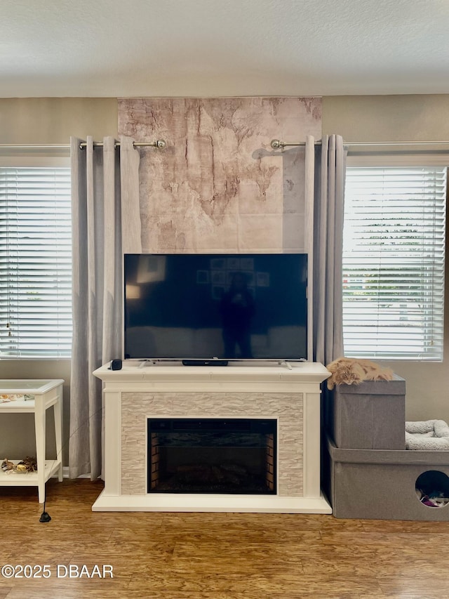 living room with hardwood / wood-style flooring, a high end fireplace, and a textured ceiling