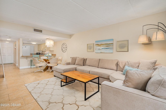 tiled living room featuring a notable chandelier