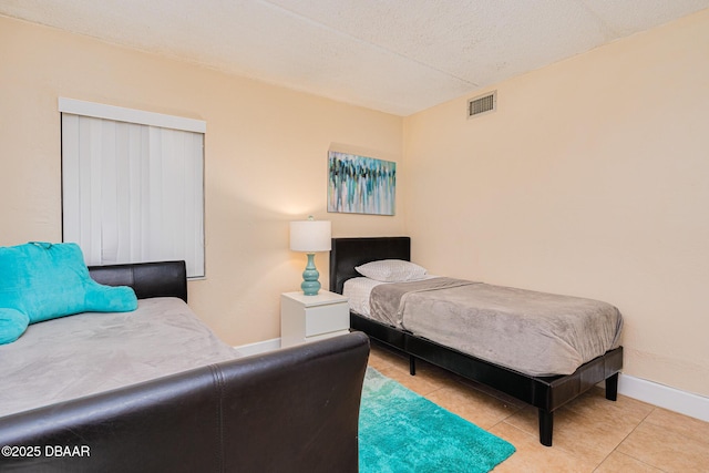 bedroom with light tile patterned flooring and a textured ceiling