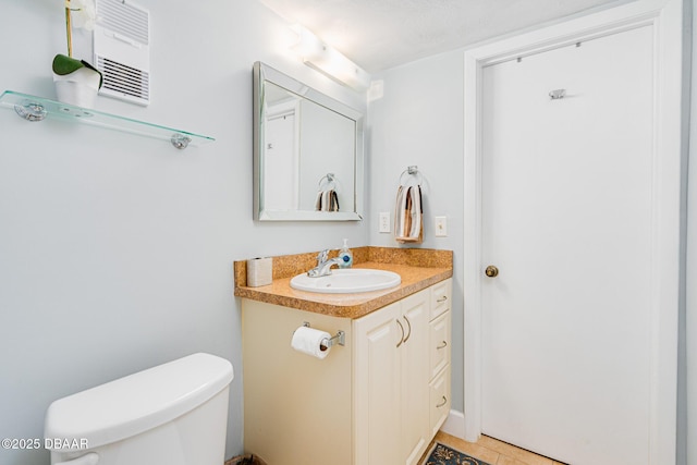 bathroom with toilet, tile patterned floors, and vanity