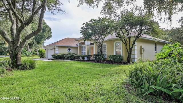 single story home featuring a garage and a front lawn