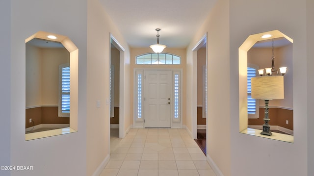 entrance foyer featuring a textured ceiling, a chandelier, and light tile patterned floors