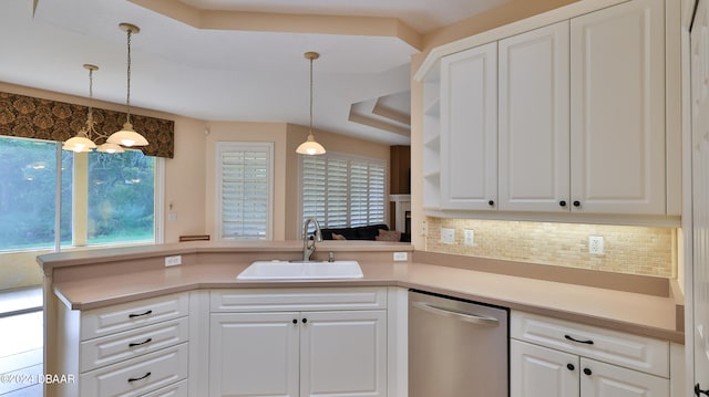 kitchen with backsplash, hanging light fixtures, sink, white cabinets, and dishwasher