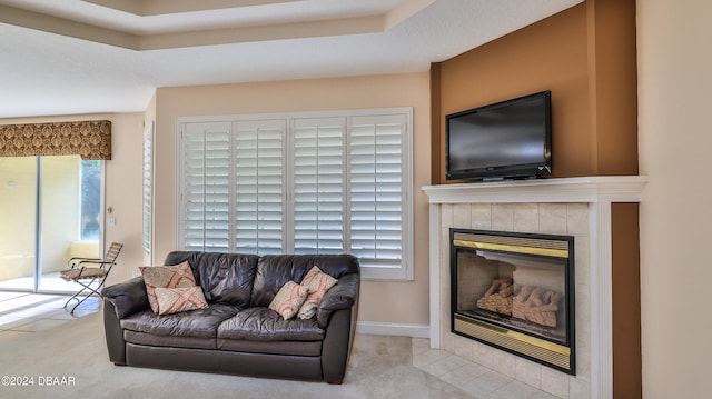 carpeted living room featuring a tiled fireplace