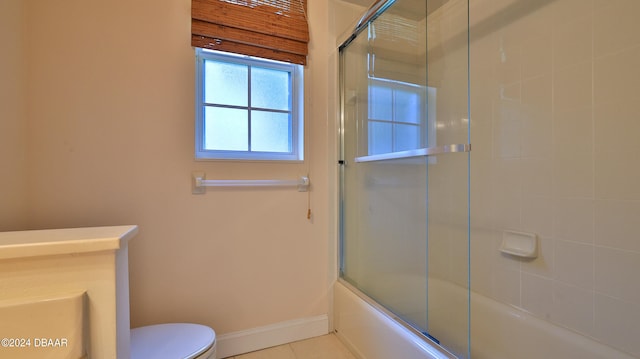 bathroom featuring combined bath / shower with glass door, tile patterned floors, and toilet