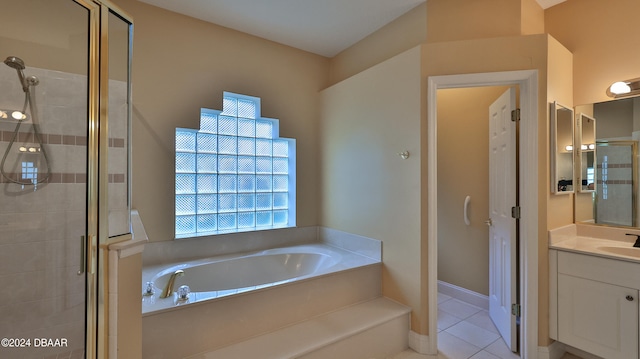 bathroom with shower with separate bathtub, vanity, and tile patterned floors