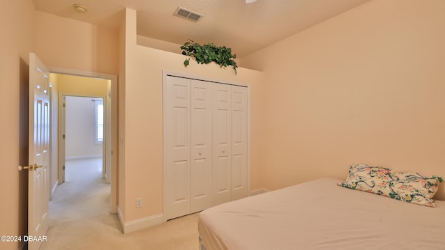 bedroom featuring a closet and light colored carpet