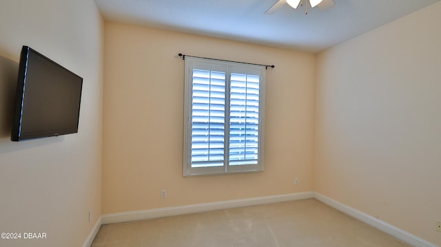 carpeted spare room featuring ceiling fan