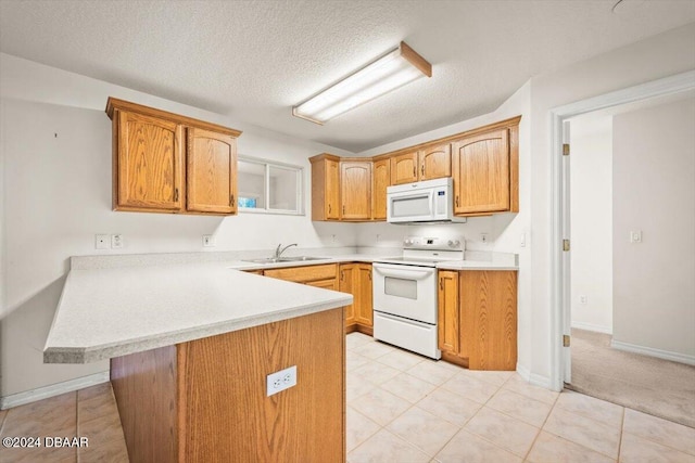 kitchen featuring sink, kitchen peninsula, a textured ceiling, light tile patterned floors, and white appliances