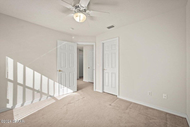 empty room featuring light carpet and ceiling fan