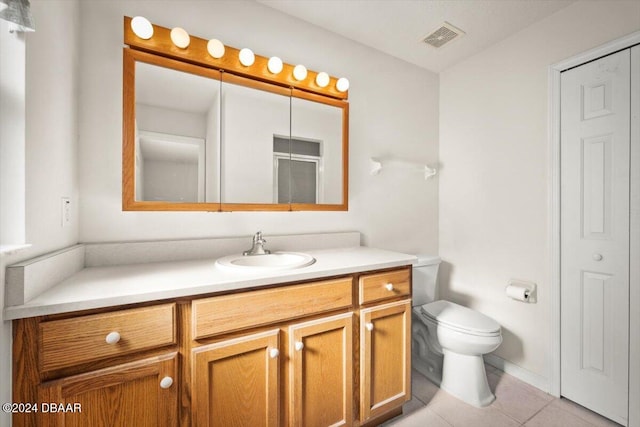 bathroom with tile patterned flooring, vanity, and toilet