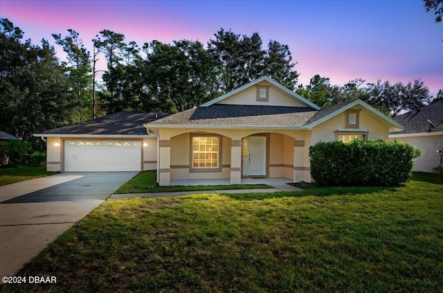 single story home featuring a lawn and a garage