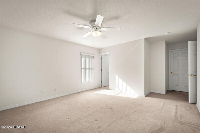 carpeted spare room featuring ceiling fan and a textured ceiling