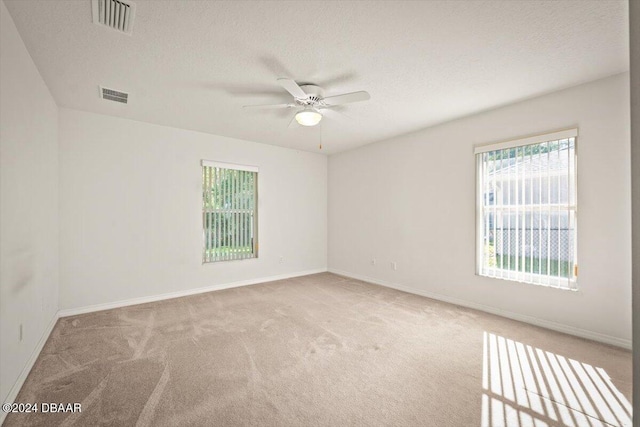 carpeted empty room featuring a textured ceiling and ceiling fan