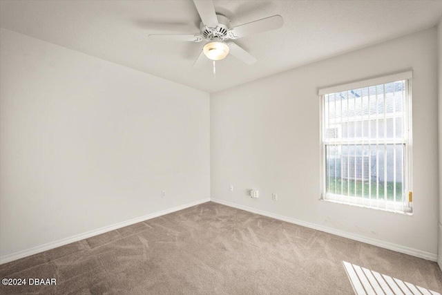 carpeted spare room with ceiling fan