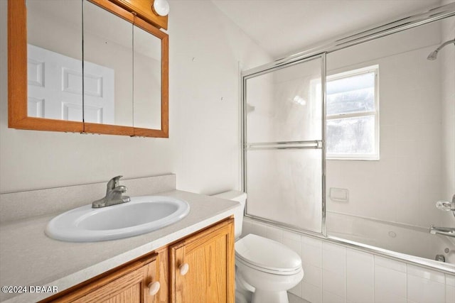 full bathroom featuring enclosed tub / shower combo, vanity, and toilet