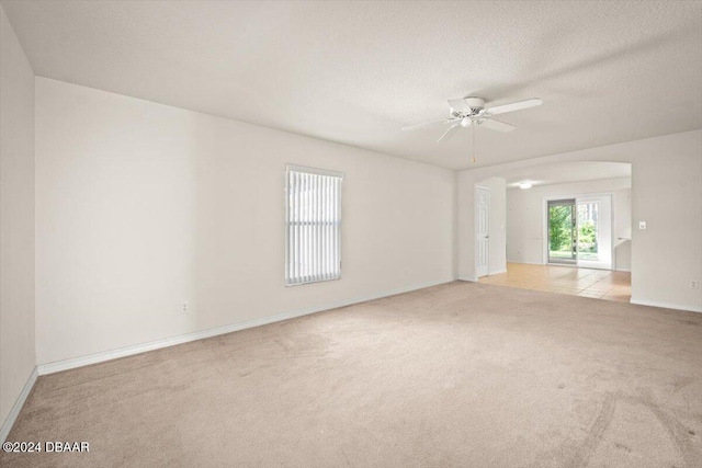 carpeted empty room featuring a textured ceiling and ceiling fan