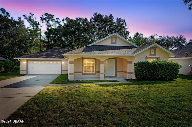 ranch-style house featuring a lawn and a garage