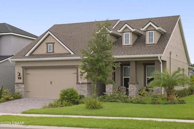 view of front of house featuring stone siding, stucco siding, decorative driveway, and roof with shingles