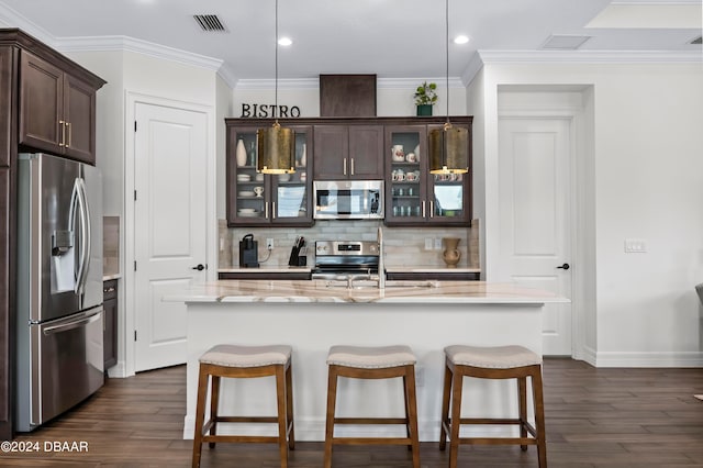 kitchen with dark wood-type flooring, appliances with stainless steel finishes, a kitchen island with sink, and hanging light fixtures