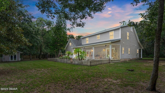 back house at dusk featuring a yard