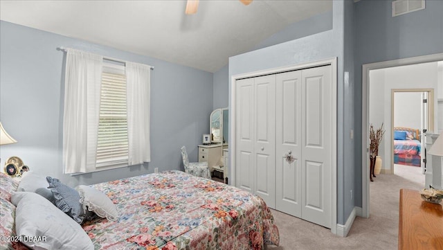 carpeted bedroom with ceiling fan, vaulted ceiling, and a closet