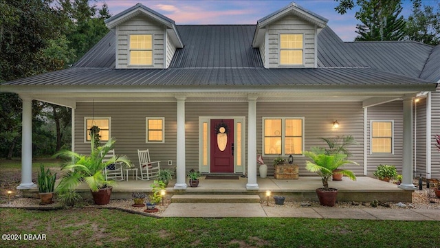 cape cod home featuring a porch