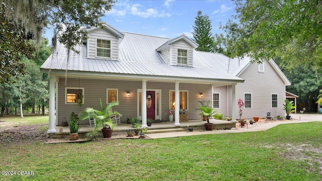 new england style home with a front yard and covered porch