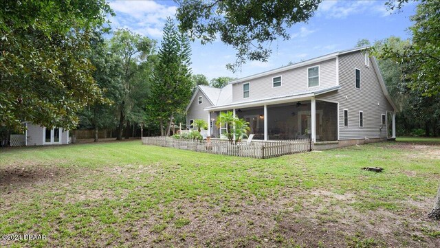 back of house featuring a sunroom and a yard