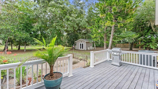 wooden terrace with an outbuilding and a grill