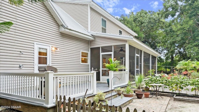 back of house featuring a wooden deck, a sunroom, and a patio area