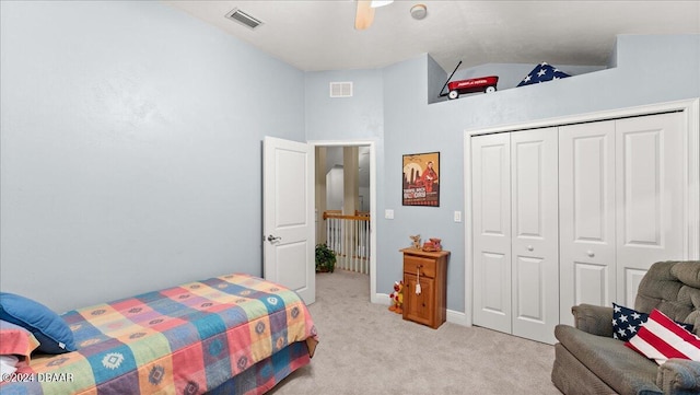 carpeted bedroom with ceiling fan, a closet, and high vaulted ceiling