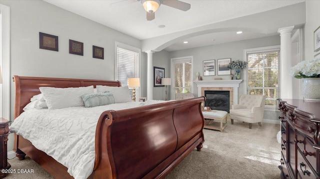 carpeted bedroom with ceiling fan and ornate columns