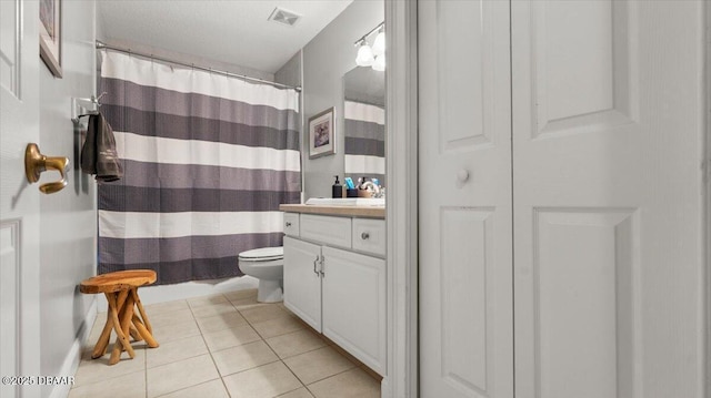 bathroom featuring tile patterned flooring, vanity, walk in shower, and toilet