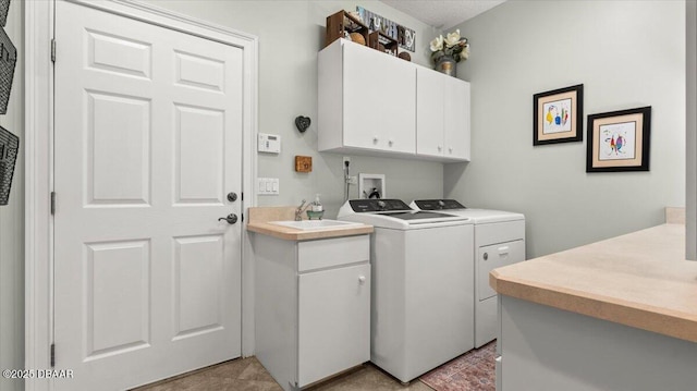 laundry area featuring cabinets, washing machine and dryer, and sink