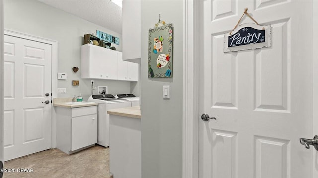 washroom with cabinets, a textured ceiling, and independent washer and dryer