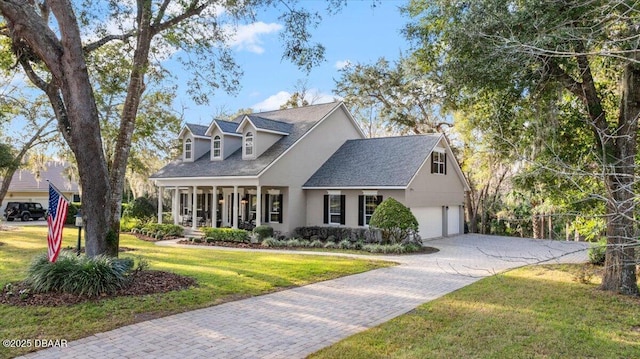 cape cod house featuring a garage, covered porch, and a front yard