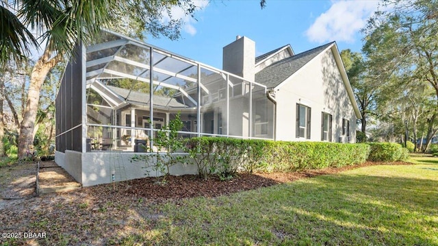 view of home's exterior featuring a yard and glass enclosure