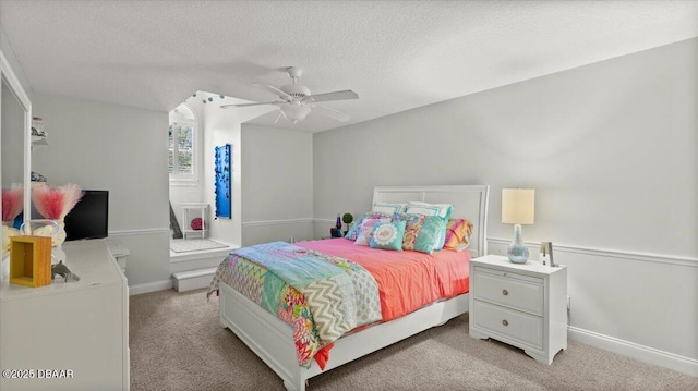 carpeted bedroom featuring ceiling fan and a textured ceiling