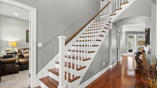 stairs with a towering ceiling and wood-type flooring