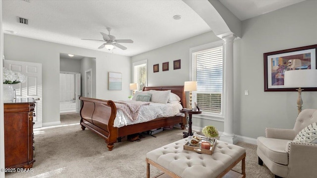 carpeted bedroom featuring ceiling fan, a textured ceiling, and ornate columns