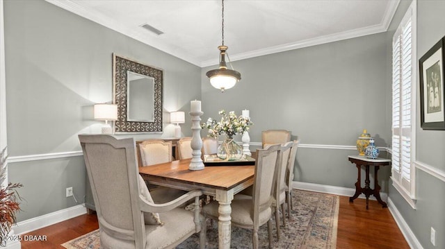 dining room with dark wood-type flooring and ornamental molding