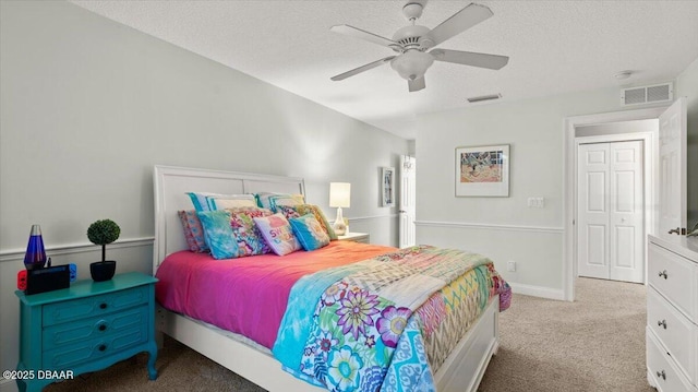 bedroom with light carpet, ceiling fan, and a textured ceiling