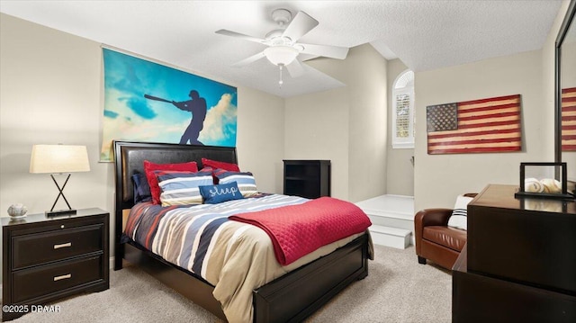 bedroom featuring ceiling fan, light colored carpet, and a textured ceiling