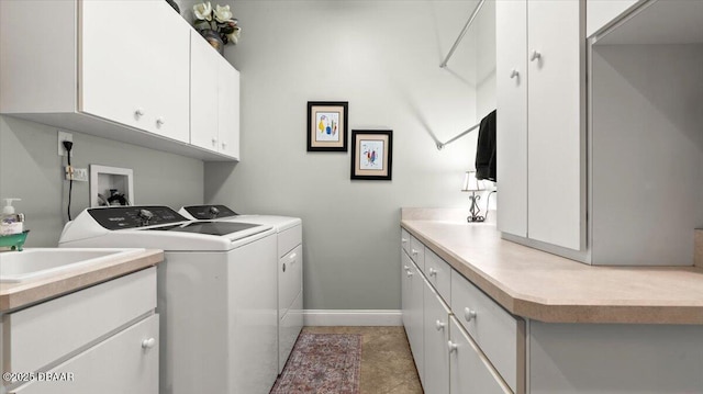 clothes washing area featuring cabinets and washer and dryer