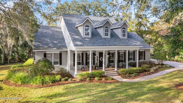 new england style home featuring covered porch and a front lawn