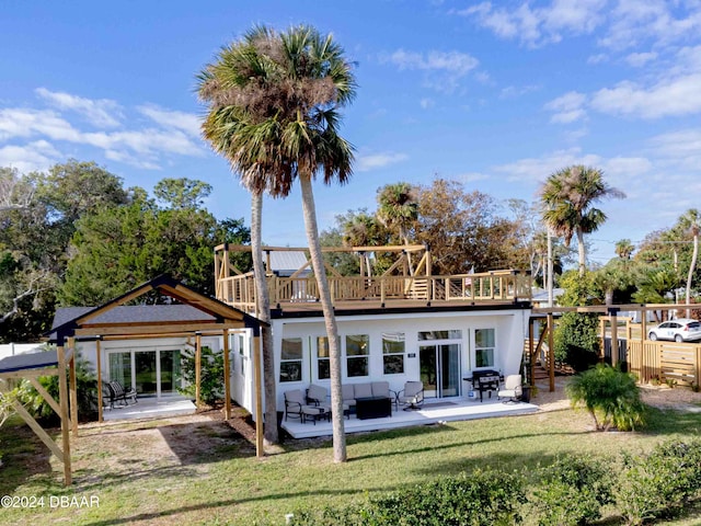 rear view of property featuring an outdoor living space, a patio area, and a lawn