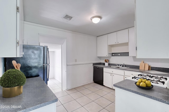 607 Marlene Dr, Holly Hill, FL 32117 - kitchen with black dishwasher, freestanding refrigerator, light tile patterned floors, dark countertops, and white cabinetry