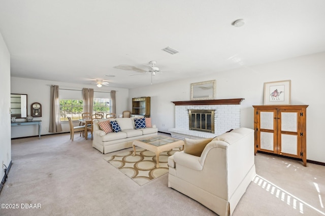 living room featuring light colored carpet, a brick fireplace, and ceiling fan